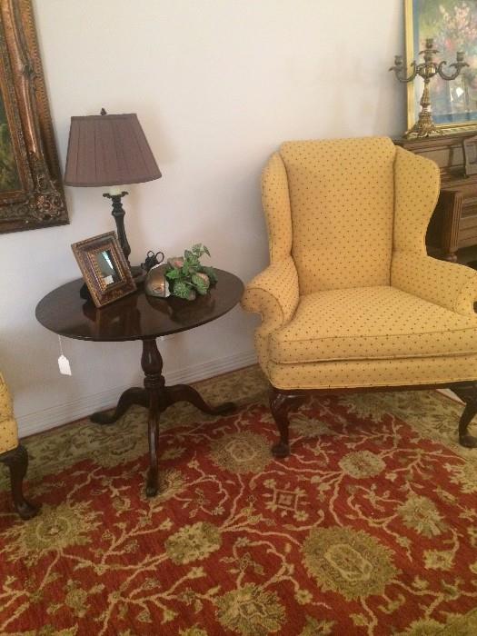 Yellow wing back chair (has matching ottoman); round 3-legged side table