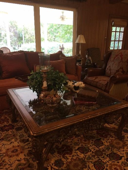 One of two sofas; large ornate coffee table; one of two recliners;