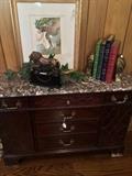 Small credenza with a marble top ; lion statue; decorative books