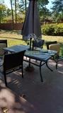outdoor table with umbrella and a set of chairs