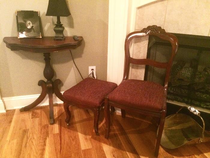 Carved chair and ottoman; three-legged end table; brass log holder with enamel handle
