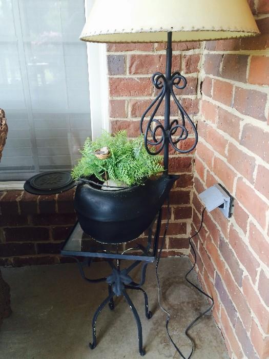 Cast-iron kettle converted to a planter/lamp on glass-top cast-iron table