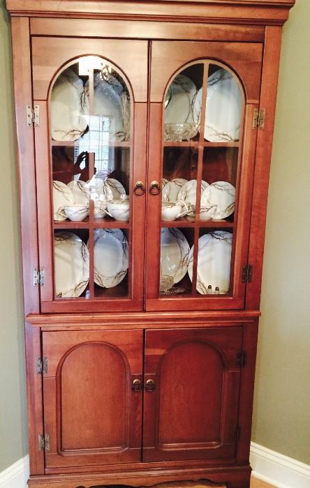 One of two matching corner curio cabinets