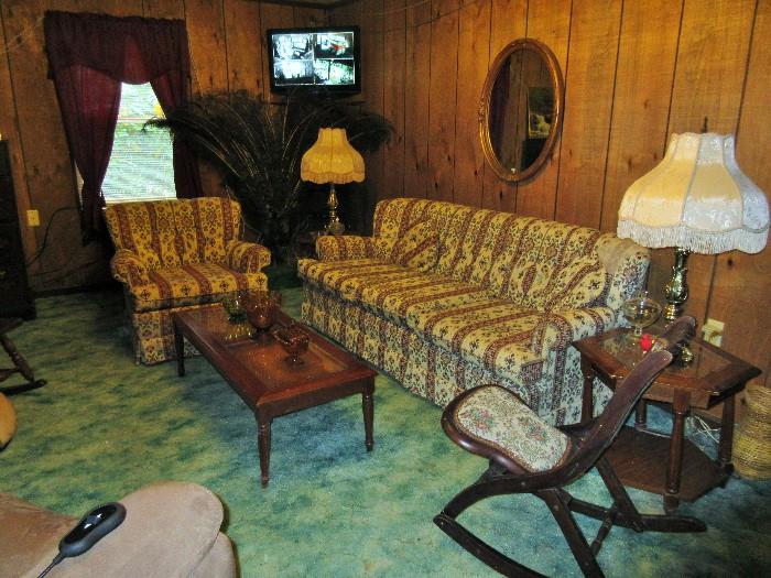 N.C. sofa and matching chair with a matching trio of coffee table and end tables.  Pair of antique reproduction lamps and vintage rocking chair.  Oval goldleaf mirror above sofa.