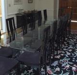 There are two separate identical glass tables and fourteen chairs, all priced separately.
