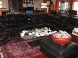 Overview of family room with black leather couch, slate coffee table and black leather ottoman (ashtrays from Europe on coffee table and matches from all over on ottoman)