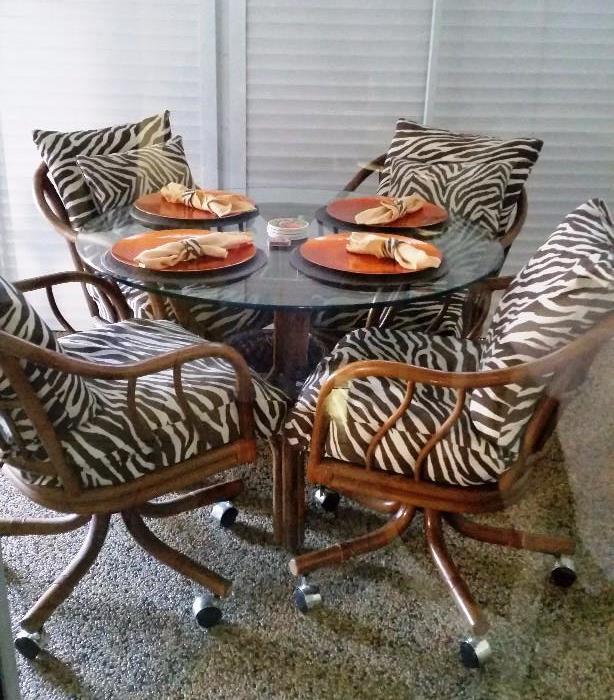 RATTAN AND GLASS PATIO SET WITH ROLLING CHAIRS WITH ZEBRA PRINT CUSHIONS-
THIS SET SET NOW LOCATED AT IT'S ALL GOOD CONSIGNMENT BOUTIQUE 