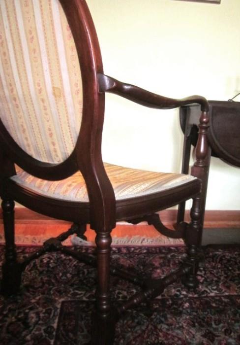 Antique, solid wood (mahogany?), arm chair with oval back and nice carving.