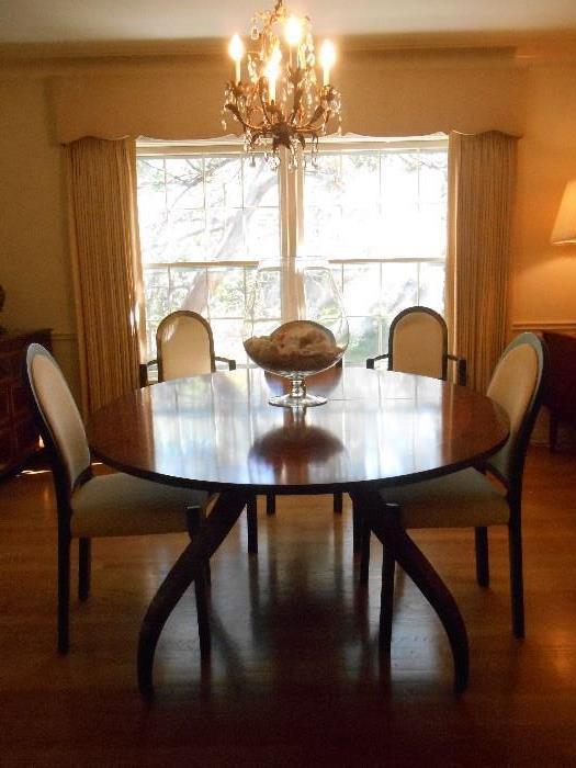 Dining Room:  HOUSE OF DENMARK oval table measures 66" x 50" and includes two 22" leaves which would make the table 110" x 50". Notice the curved legs on the table.   Eight (2 arm and 6 side) HOUSE OF DENMARK chairs are also available.  A large brandy snifter of shells is on the table. The chandelier is also for sale (it is 18" tall and 15" wide).
