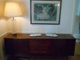 Dining Room: HOUSE OF DENMARK sideboard/credenza is 6' 4" wide x 31" tall x 17-l/2" deep. It has a sliding door on each side and four shallow drawers in the middle. The glass lamp on the left is Finnish, and the modern lithograph is signed and numbered (74/95) by Swedish artist HANS ERNI (measures 36" wide x 29" tall).