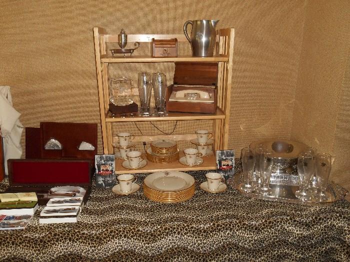 Family Room: A collection of various Anheuser-Busch items includes:  a carving set in a box; napkin rings/iced teaspoons/coasters in a box; wooden rolodex; pitcher; telephone case; Pilsners; silver-plate tray; LENOX china with the A-B logo; VHS tapes on brewing; pen/pencil sets and a few more things.