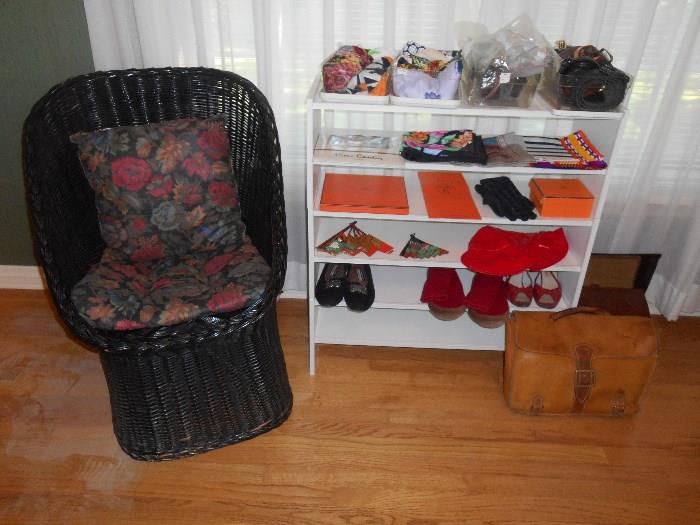 Bedroom #1:  A black wicker chair with two floral pads; a 3-part display unit; scarves; belts; shoes; empty HERMES boxes; and a few brief cases.