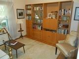 Bedroom #3: A four-piece contemporary beech wood storage system has a TOTAL width of 8' 7" x 6' 7" tall and 15-l/2" deep. There are several drawers and doors as well as one drop down unit. Also shown are tables and lamps and decorative items.