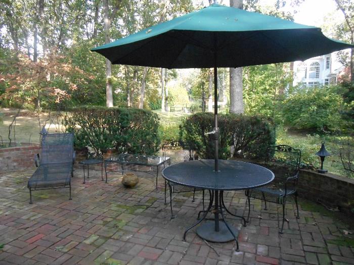 Outside patio:  A chaise lounge; small mesh table; glass top/iron table; patio table; umbrella; two chairs.