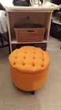 Orange padded stool that opens, many pieces of accent furniture.
