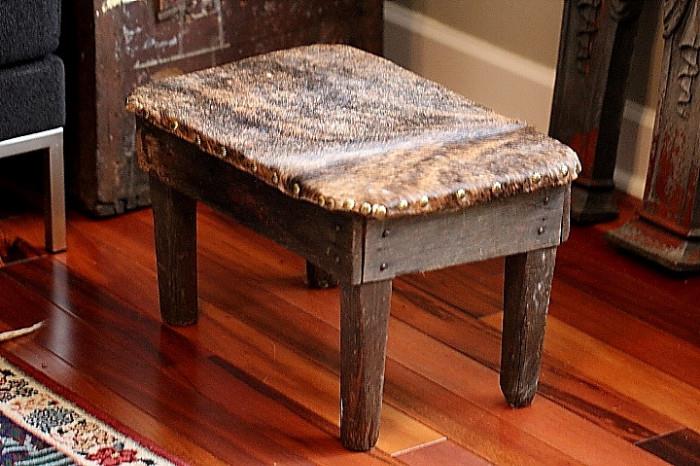 neat old primitive footstool covered in fur