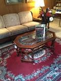 One of two sofas; one of several rugs; glass top coffee table