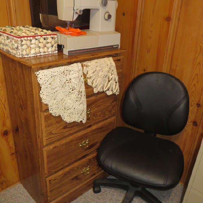 Chest of drawers; office chair; shell sewing box; portable sewing machine.