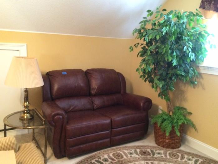 leather love seat recliner,  lighted tree, glass top table , lamp