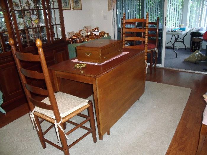 Cherry drop leaf dining table and 6 chairs.  Possibly made by the Amish.  Also comes with table pads