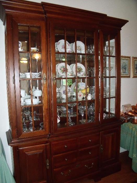 Stanley Norman Rockwell Collection cherry colonial style china cabinet.  Lighted upper with glass shelves.  Three lower drawers, one lined for silver/flatware.