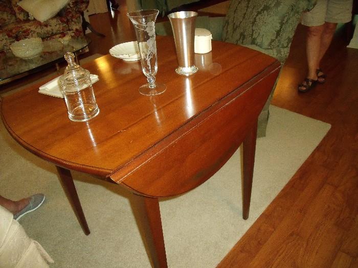 Hitchcock table - cherry with small drop leaf sides.  Table comes with pads in order to use as a small dining table.  