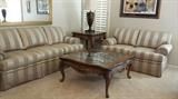 Robb & Stucky rolled-arm sofa and love seat. Large mirror over the sofa. French carved-wood legs and marble insets on the coffee table and end table. 