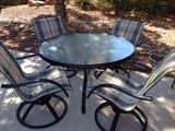 Round black metal table and 4 swivel rocker armchairs with black & tan mesh seat fabric. 