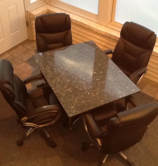 Modern styled, granite topped game table (also has a interchangeable glass top) with 4 black leather, adjustable, chairs on roller.