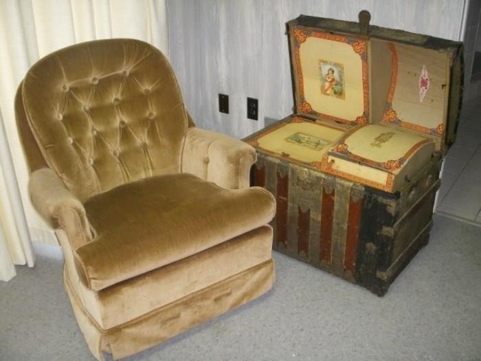 Comfy chair next to an antique trunk complete with its inner tray