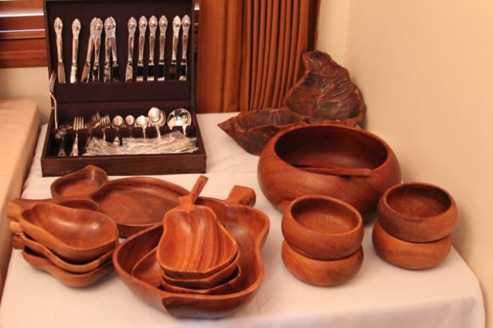 Wooden salad bowls and serving pieces. Silver cutlery.