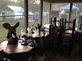 Wood tables, ceramic and glass eagle statues, bar stools. 