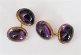 Lot #43: 18k Gold Amethyst Cuff Links
 four oval cabochon cut amethysts  each weighing approximately 15 ct each with chased mounting