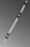 Lot#46: Cartier Art Deco Platinum and Diamond Bracelet
 center European cut diamond approximately .70 cts,  4 European cut diamonds each approximately .50 cts, with black onyx links circa 1925
