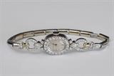 Lot#47: Concord Platinum and Diamond Wrist Watch
 set with round brilliant cut diamonds and two marquise diamonds each approximately .25 cts 17 jewel manual wind movement approximately 6.9 dwt gross with gold filled expansion bracelet