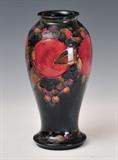 lot 144: Moorcroft Vase
 baluster form Pomegranate pattern 9 1/4" high with green script signature early 20th century