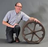 lot 332: Cast Iron Tractor Fly Wheel
 with heart cut-outs together with base and glass top to use as a side table 24" diameter embossed "Patented Feb 19, 1901"