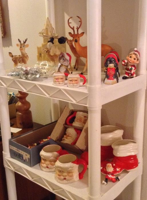 Xmas decorations: lighted music box church by Raylite, plastic deer, vintage winking Santa mugs (made in Japan), ceramic Santa boots, rollerskating Santa ornaments