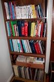 2 of 4 bookshelves filled with world travel guides, home repair and gardening books and other references