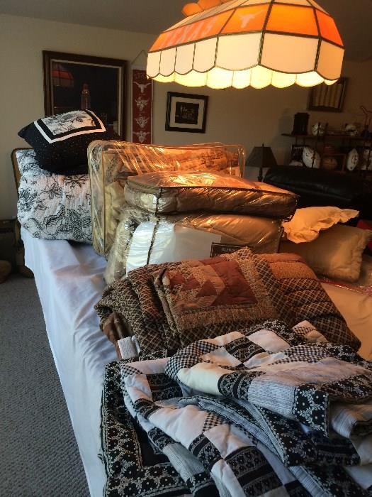 Many quilts and comforters; one king quilt that has never been used!