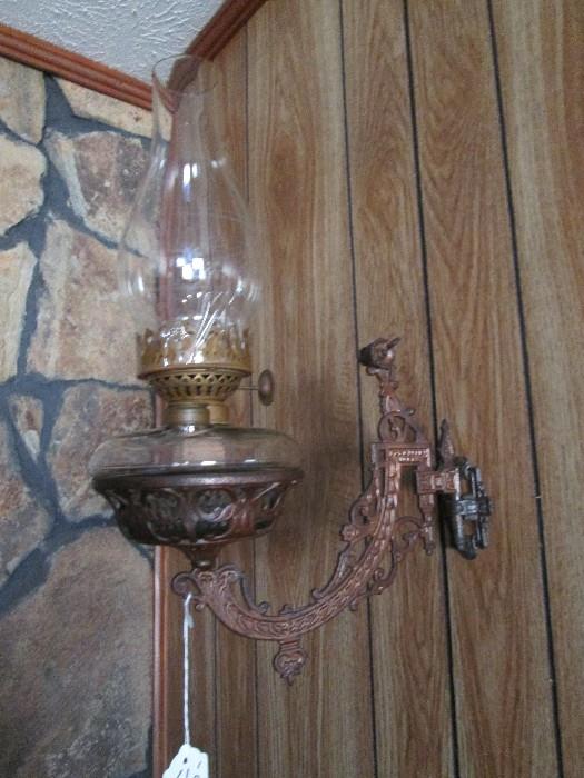 Kerosene lamp on cast iron wall bracket