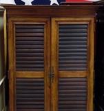 Louvered door entertainment/wardrobe with 7 drawers on bottom interior.