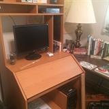 Computer desk; monitor; brass lamp; computer