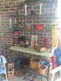 Baker's rack/plant stand with assorted planters, bird feeders, and baskets