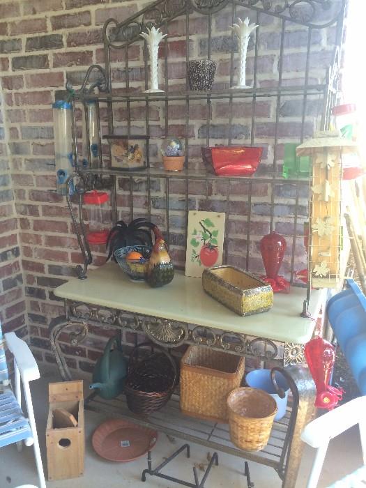 Baker's rack/plant stand with assorted planters, bird feeders, and baskets