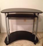 Black computer table with slide-out tray for your keyboard.