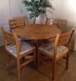 Douglas Furniture dinette with 4 chairs. 2 sides drop down to save space if there's only 2 diners. 