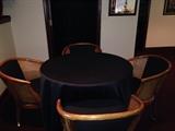 Table and 4 cane barrel chairs with casters and brass foot rest