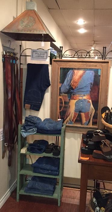 Two copper hanging lamps (one shown), cowgirl print, jeans and belts.