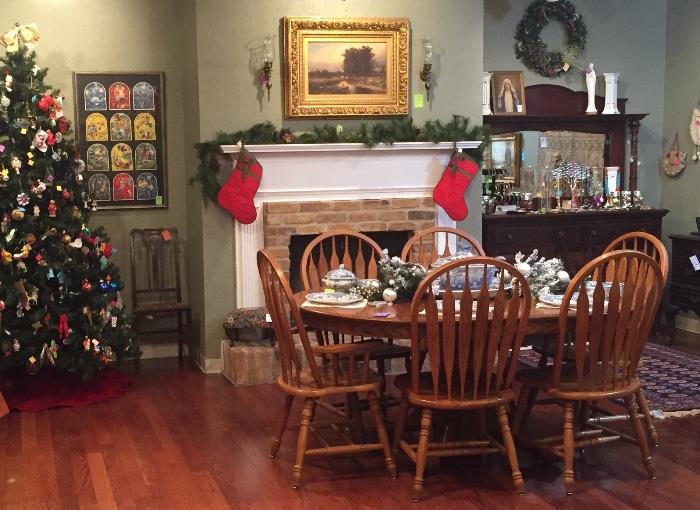 Oak dining set with six chairs and tree full of ornaments.